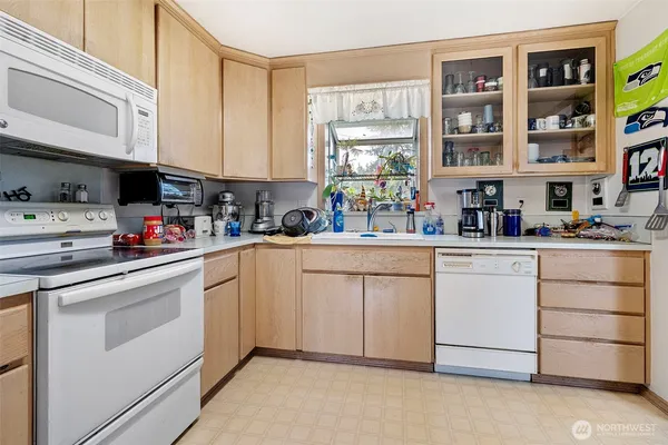 a kitchen with white cabinets and white appliances