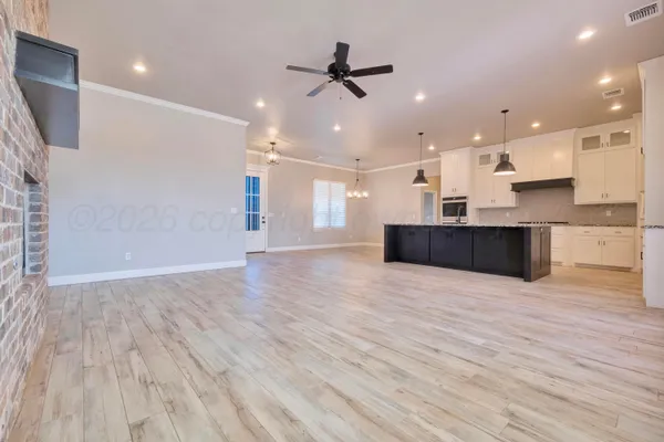 a view of kitchen and empty room with wooden floor