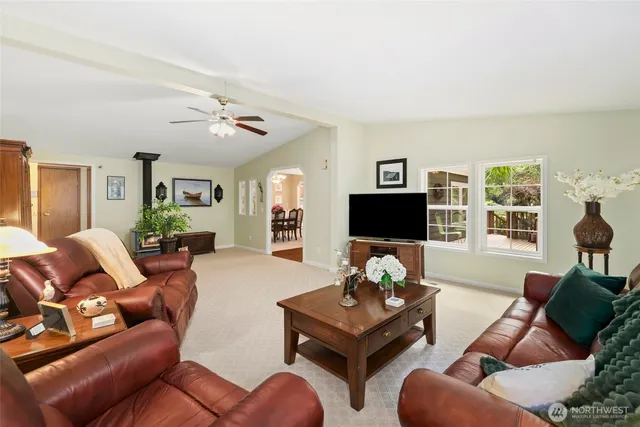 a living room with furniture a flat screen tv and a window