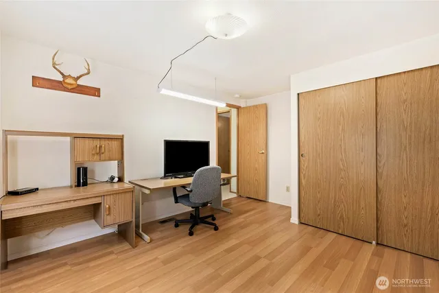 a view of a workspace with furniture and a window