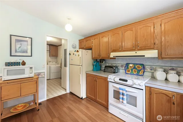 a kitchen with a refrigerator a stove a sink and cabinets