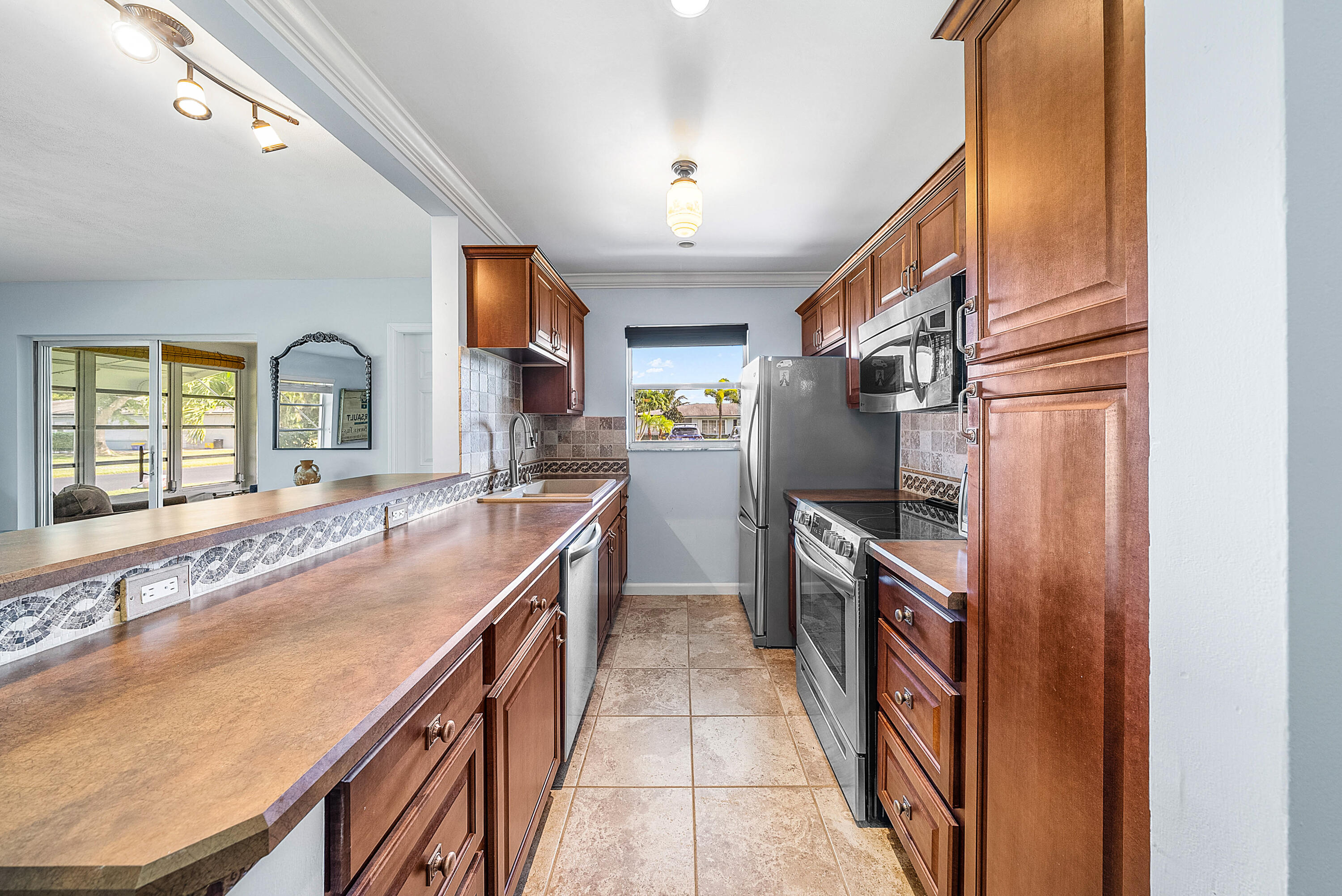 510 High Point Drive, Unit D Delray Beach, FL 33445 - Photo 7 of 23 a kitchen with granite countertop a stove and a refrigerator