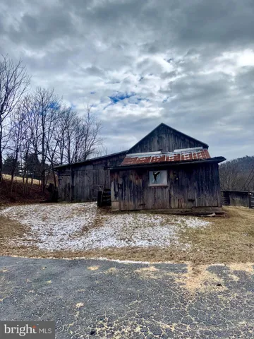 a wooden house with a large trees covered with wooden fence