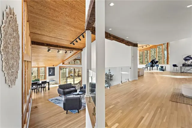 a living room with furniture large window and wooden floor