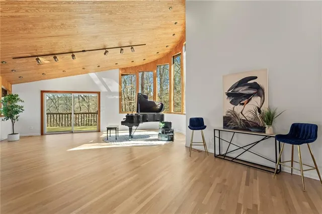 a spacious bedroom with a bed and a wooden floor