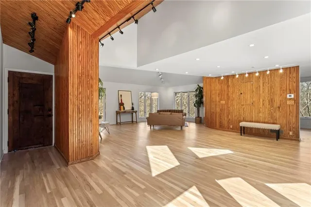a dining room with wooden floor a chandelier a glass table and chairs