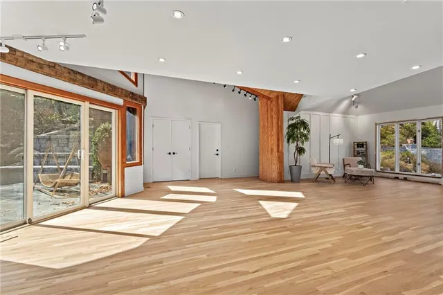 a spacious bedroom with a bed and wooden floor