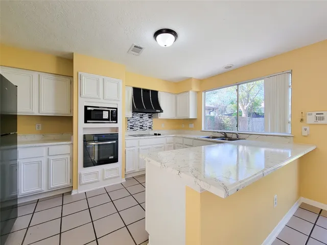 a kitchen with kitchen island granite countertop a stove sink and cabinets