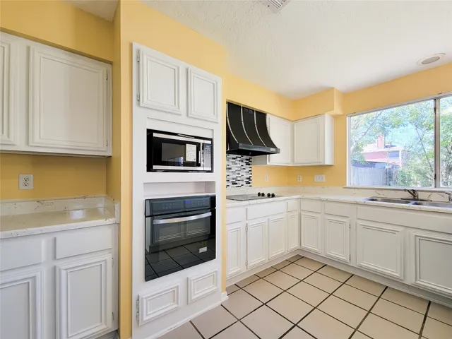 a kitchen with white cabinets and appliances