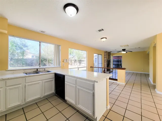 a large white kitchen with a sink and cabinets