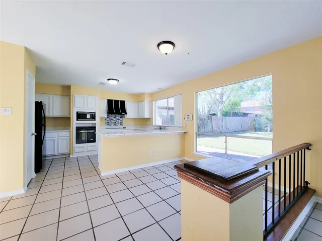 a kitchen with granite countertop a refrigerator and a stove top oven