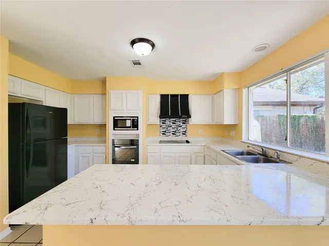 a view of a room with a hanging light and hardwood