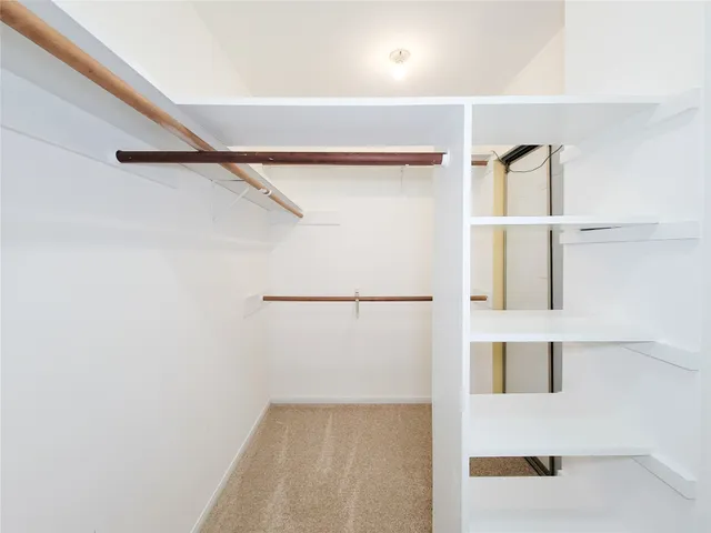 a view of an empty room and a ceiling fan & entryway