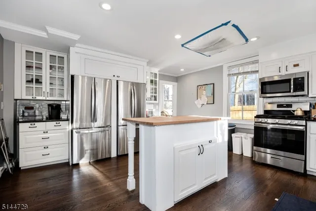 a kitchen with white cabinets and stainless steel appliances