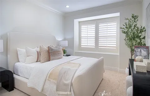 a bedroom with a large bed and a potted plant