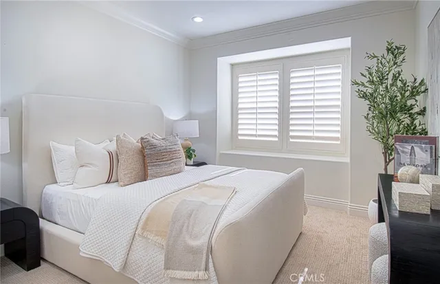 a bedroom with a large bed and a potted plant