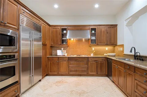 a kitchen with granite countertop stainless steel appliances and wooden cabinets