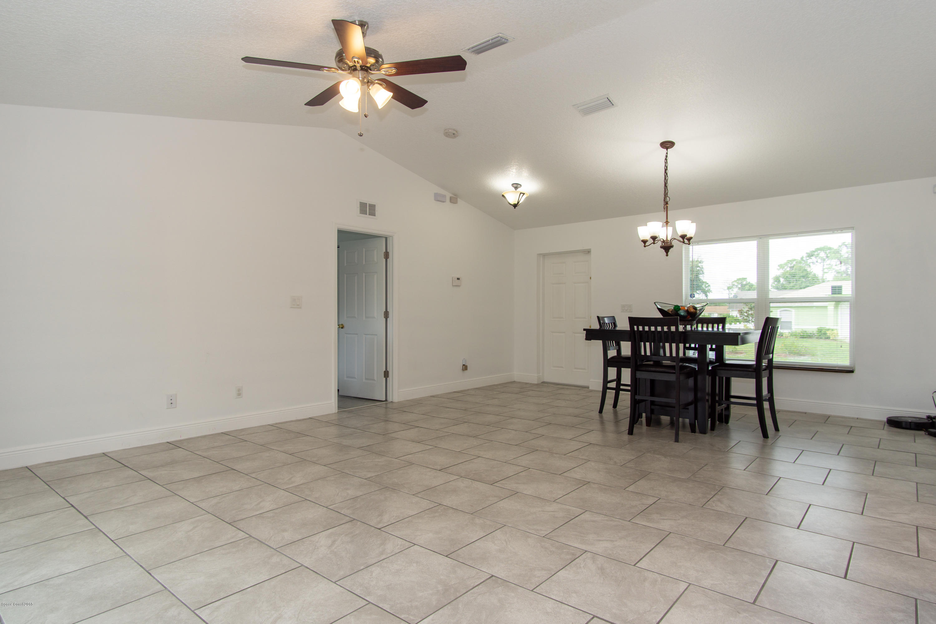 1543 Paragon Road Southeast Palm Bay, FL 32909 - Photo 11 of 18 Living/Dining with cathedral ceiling