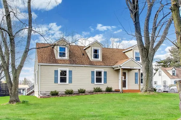 a front view of a house with a garden and trees