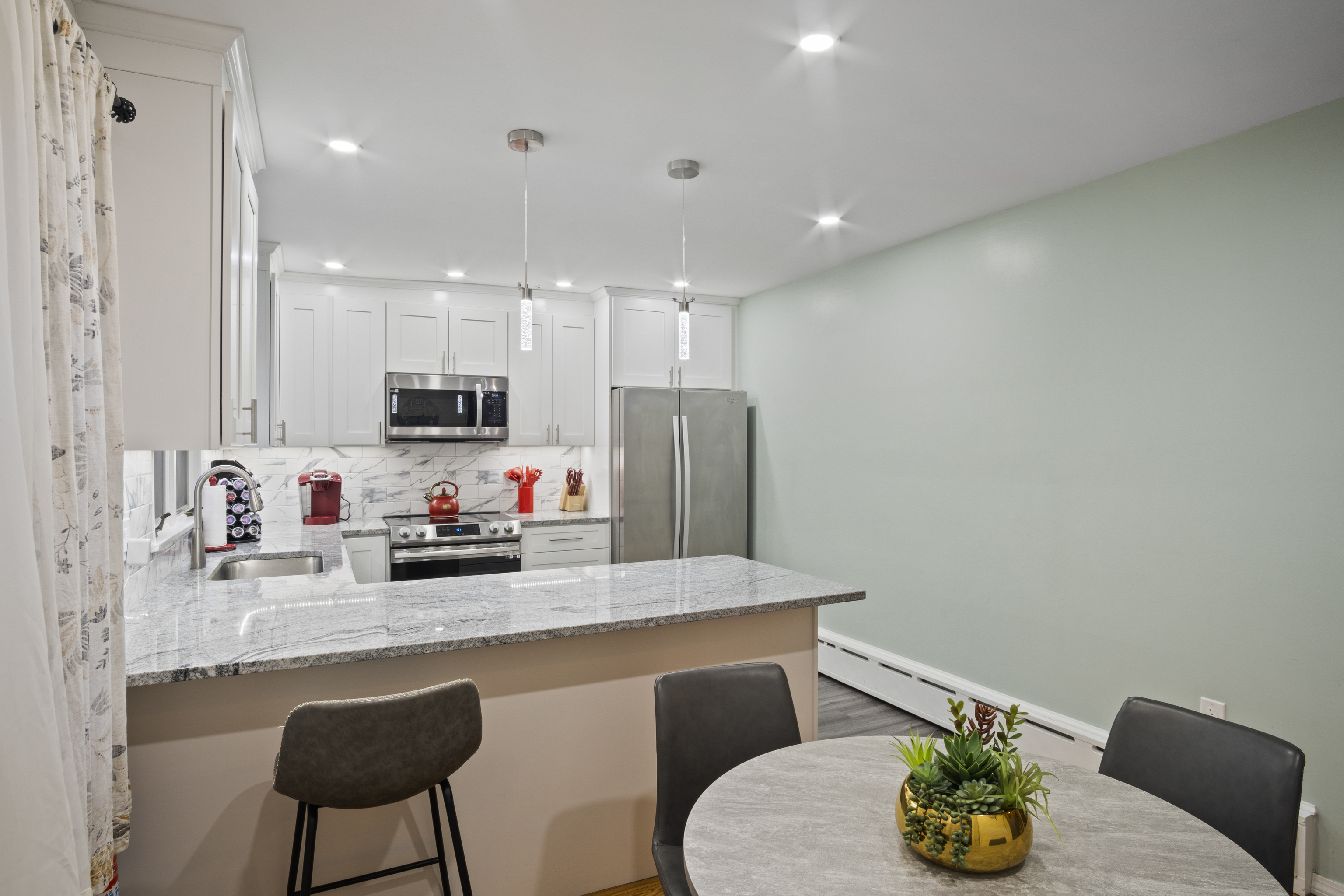 33 Briar Hill Road Norwich, CT 06360 - Photo 10 of 33 a kitchen with stainless steel appliances kitchen island granite countertop a refrigerator a sink a stove a dining table and chairs with wooden floor