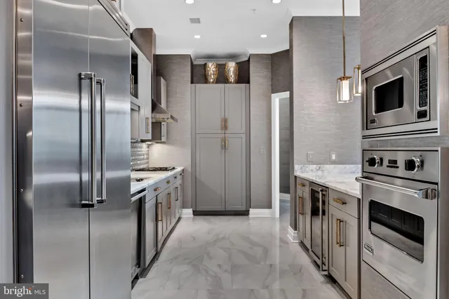 a view of a hallway with wooden floor and a bathroom