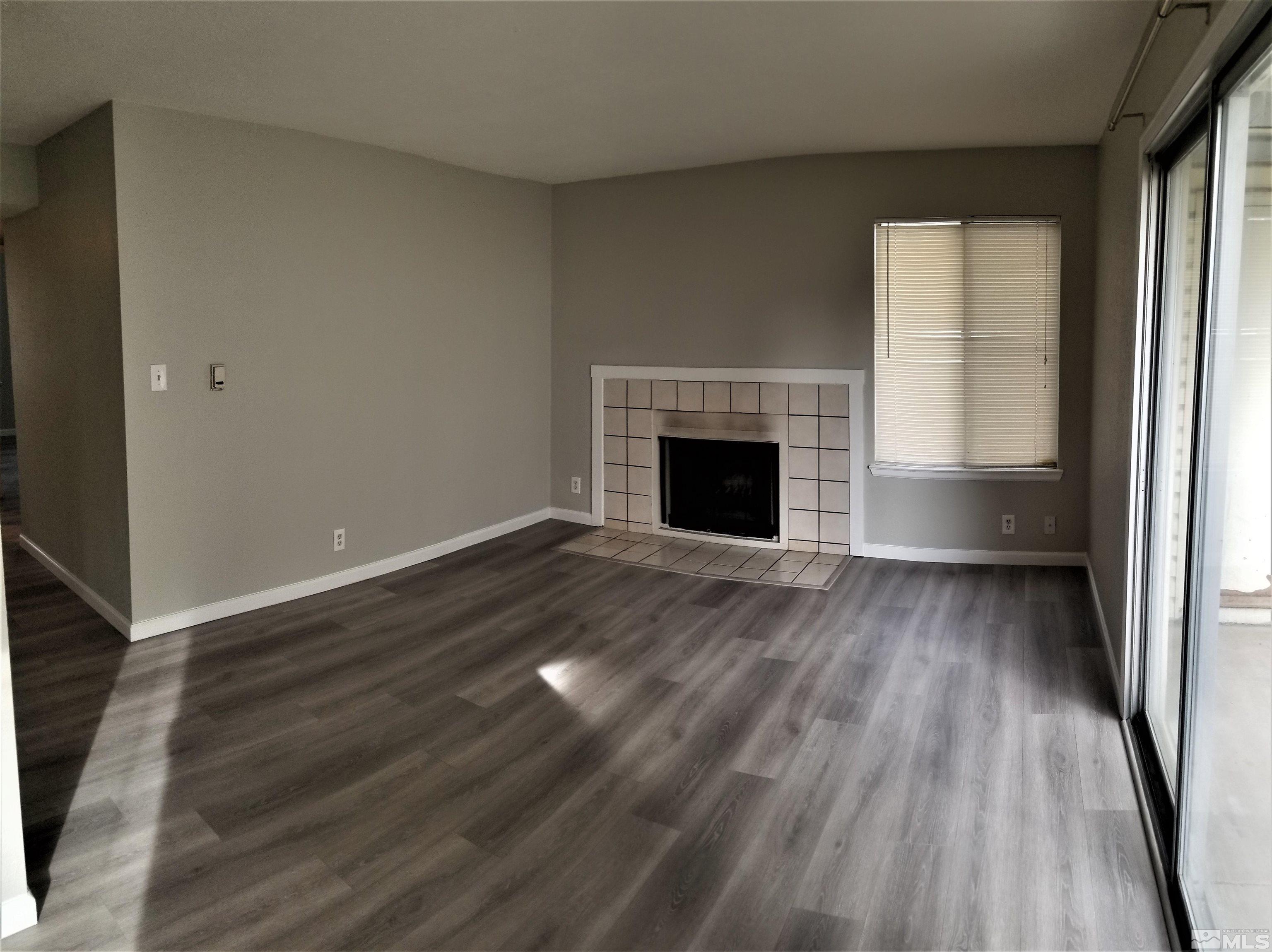 1533 Delucchi Lane Reno, NV 89502 - Photo 5 of 21 a view of an empty room with wooden floor fireplace and a window
