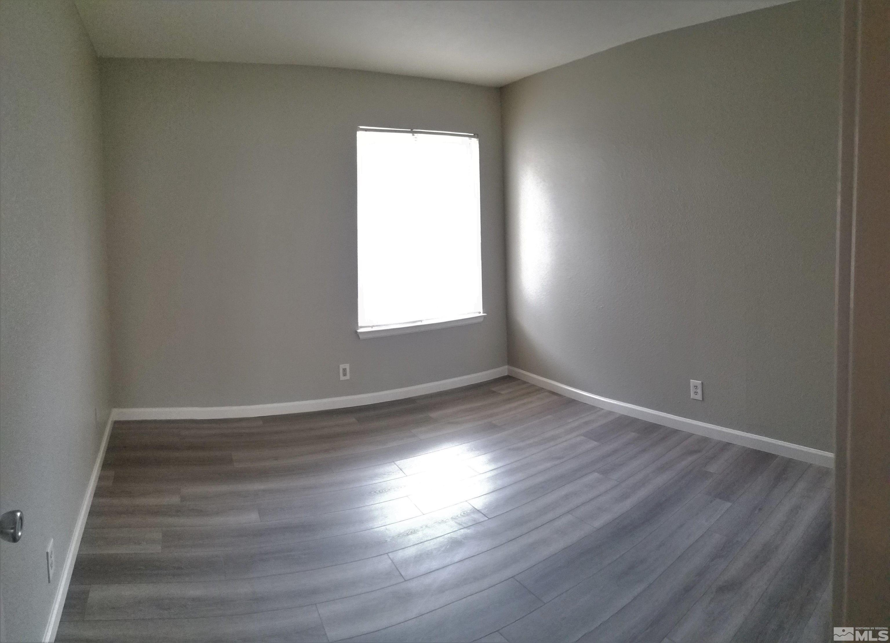 1533 Delucchi Lane Reno, NV 89502 - Photo 9 of 21 an empty room with wooden floor and windows