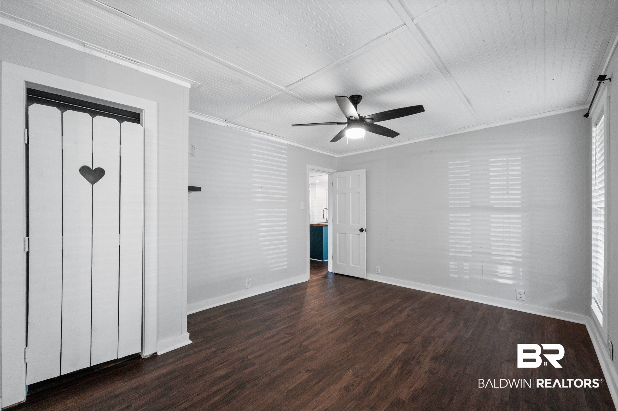 503 North Holly Street Foley, AL 36535 - Photo 11 of 23 Unfurnished room featuring ornamental molding, dark wood-type flooring, and ceiling fan