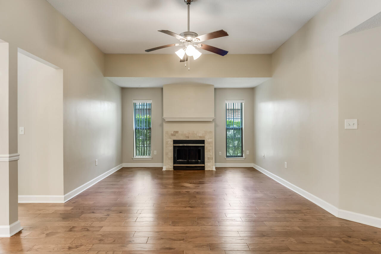 2808 Ping Lane Crestview, FL 32539 - Photo 12 of 33 an empty room with wooden floor fireplace and windows