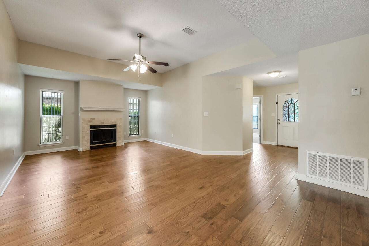 2808 Ping Lane Crestview, FL 32539 - Photo 13 of 33 an empty room with wooden floor fireplace and windows