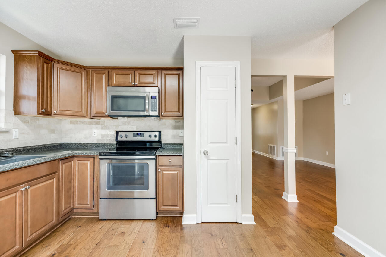2808 Ping Lane Crestview, FL 32539 - Photo 20 of 33 a kitchen with a refrigerator stove and wooden cabinets