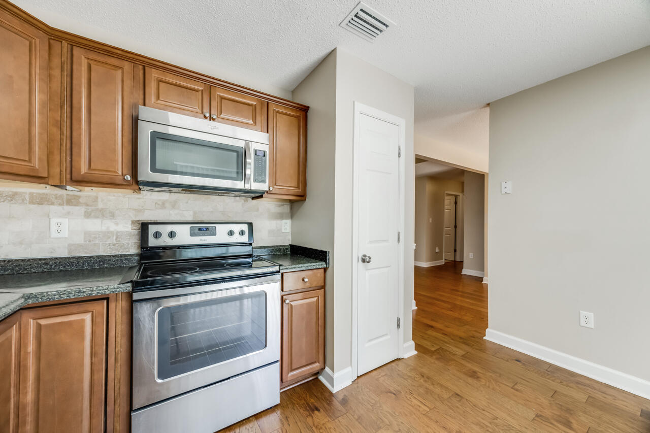 2808 Ping Lane Crestview, FL 32539 - Photo 22 of 33 a kitchen with granite countertop cabinets stainless steel appliances and wooden floor