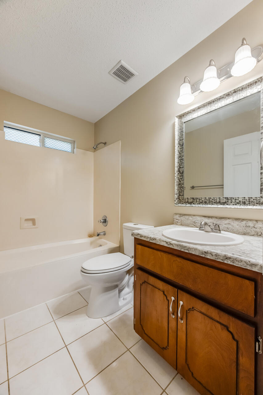 2808 Ping Lane Crestview, FL 32539 - Photo 32 of 33 a bathroom with a granite countertop sink a toilet mirror and bathtub