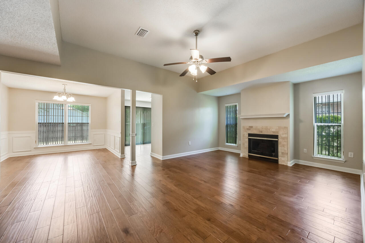 2808 Ping Lane Crestview, FL 32539 - Photo 9 of 33 an empty room with wooden floor fireplace and windows