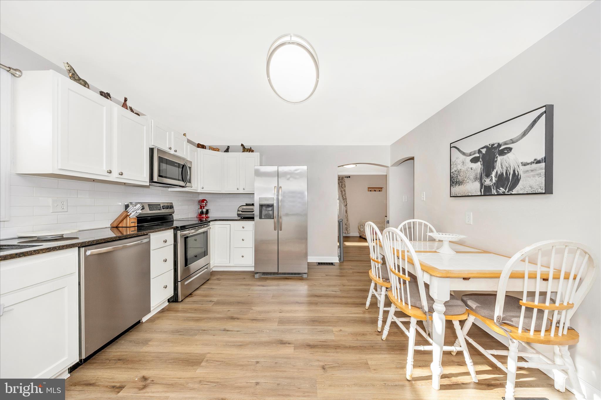 11863 Wolfsville Road Smithsburg, MD 21783 - Photo 11 of 51 a kitchen with granite countertop a table chairs microwave and cabinets
