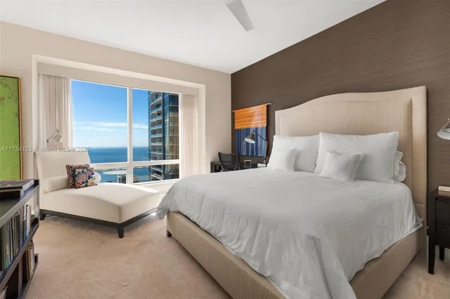 a bedroom with a bed lamp and a large window