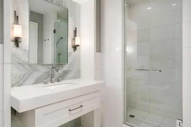 a bathroom with a sink shower and a mirror