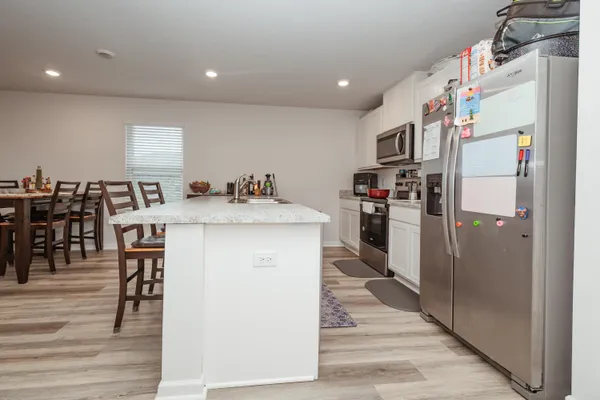 a kitchen with stainless steel appliances kitchen island granite countertop a refrigerator and a stove top oven