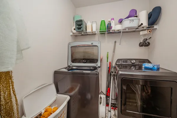 a utility room with dryer washer and a view of living room