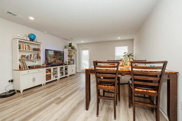 a kitchen with stainless steel appliances kitchen island granite countertop a table chairs and a refrigerator