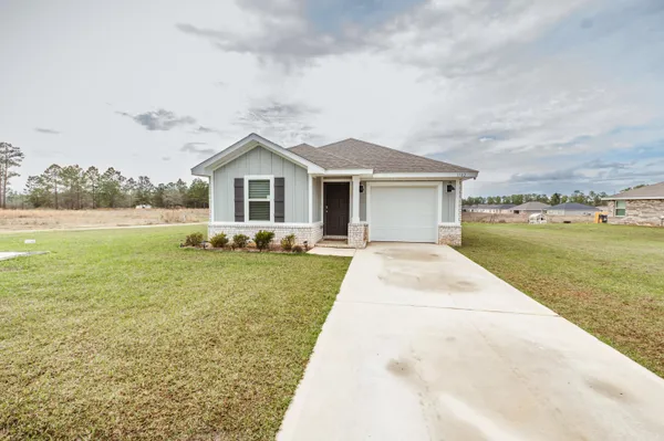 a view of a house with a yard and potted plants