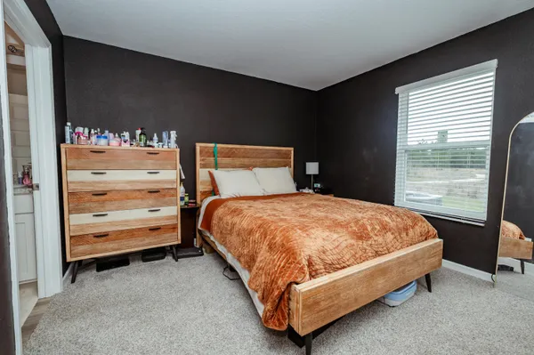 a bed sitting in a bedroom next to a window