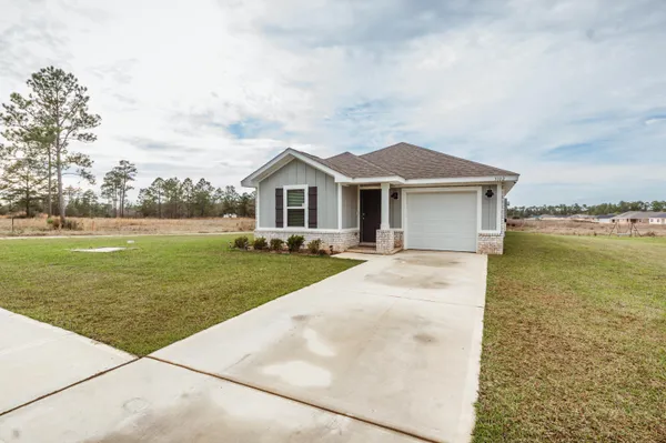 a view of a house with a yard and lake view
