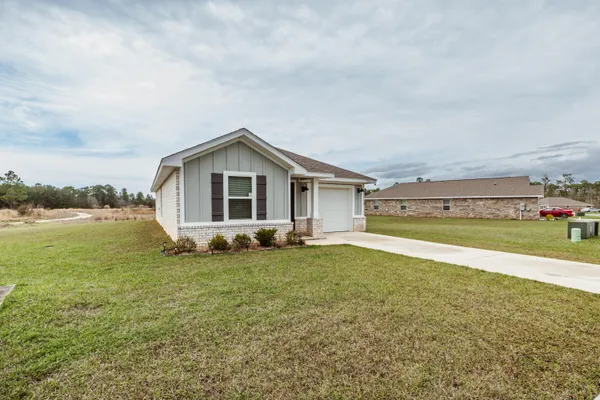 a view of a house with a big yard and large trees