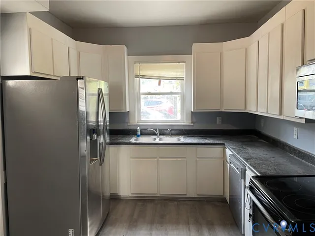 a kitchen with stainless steel appliances granite countertop a refrigerator and a sink