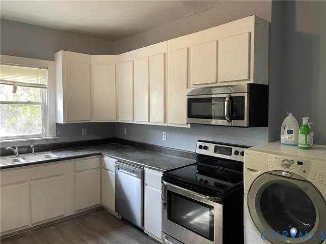 a kitchen with white cabinets and stainless steel appliances
