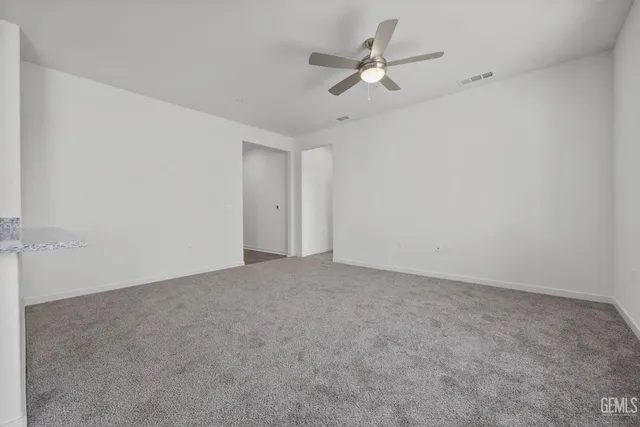 an empty room with a ceiling fan and a window