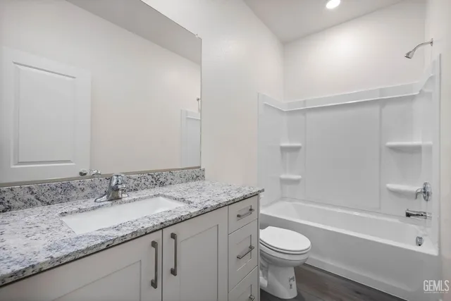 a bathroom with a granite countertop toilet sink and bathtub