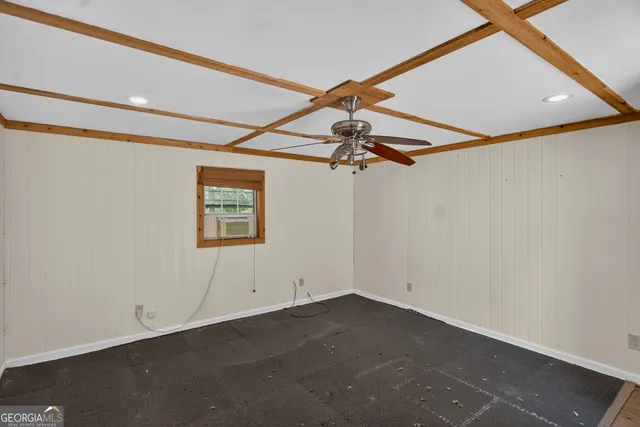 an empty room with a ceiling fan and window