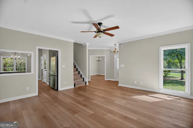 a view of a livingroom with wooden floor and a ceiling fan
